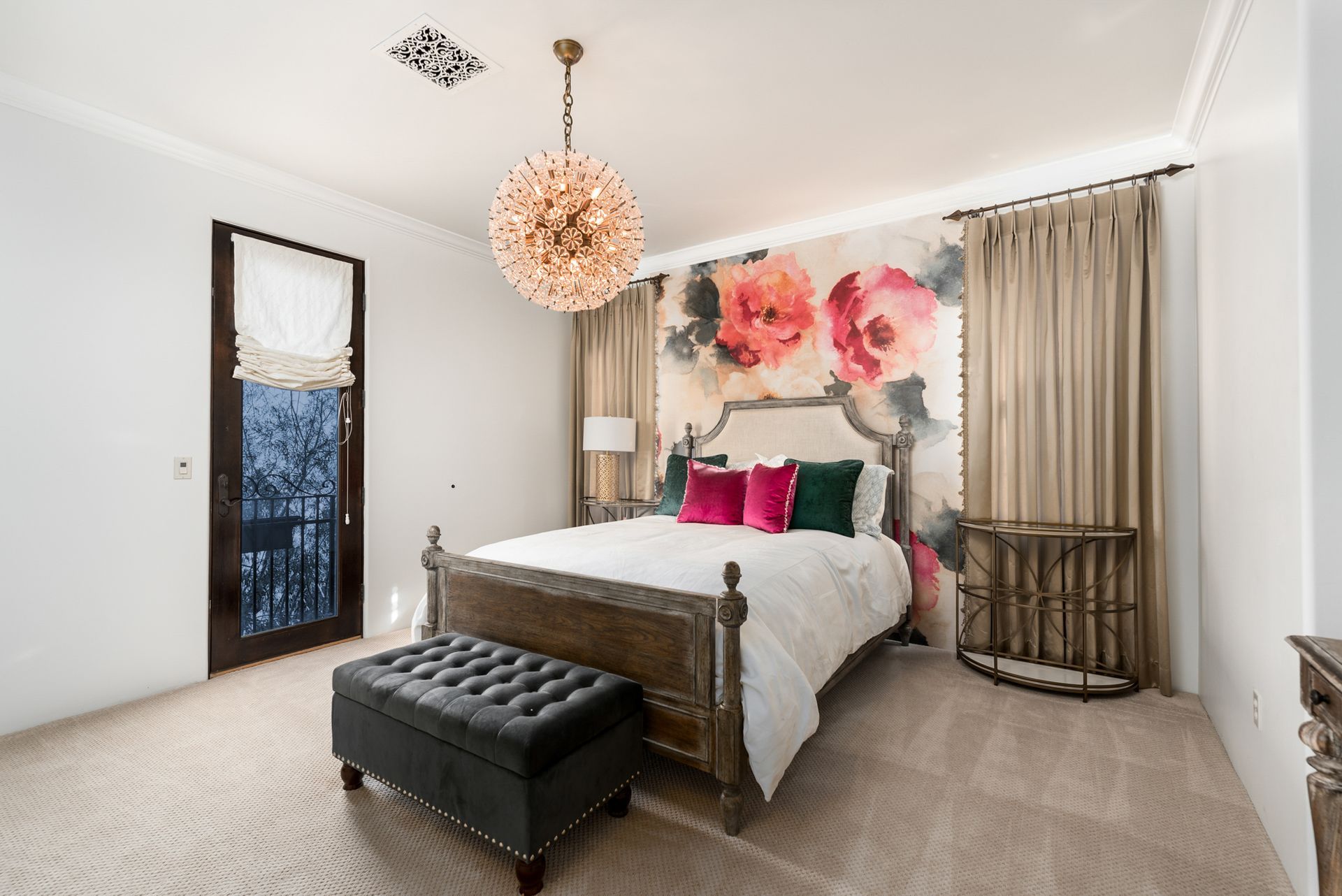 bedroom with floral accent wall and chandelier