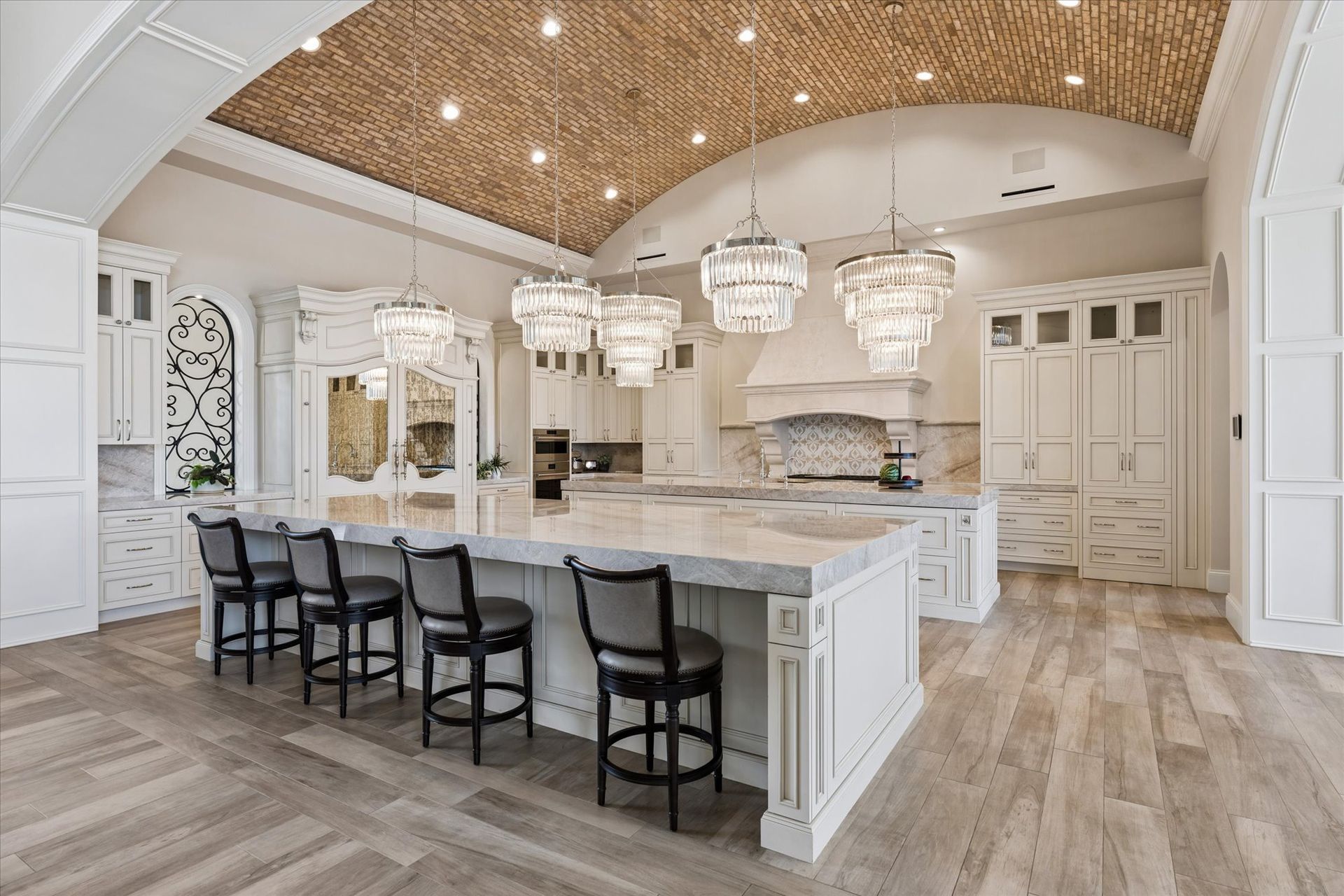 Luxury modern French kitchen with dual islands, hidden fridge, and brick ceiling