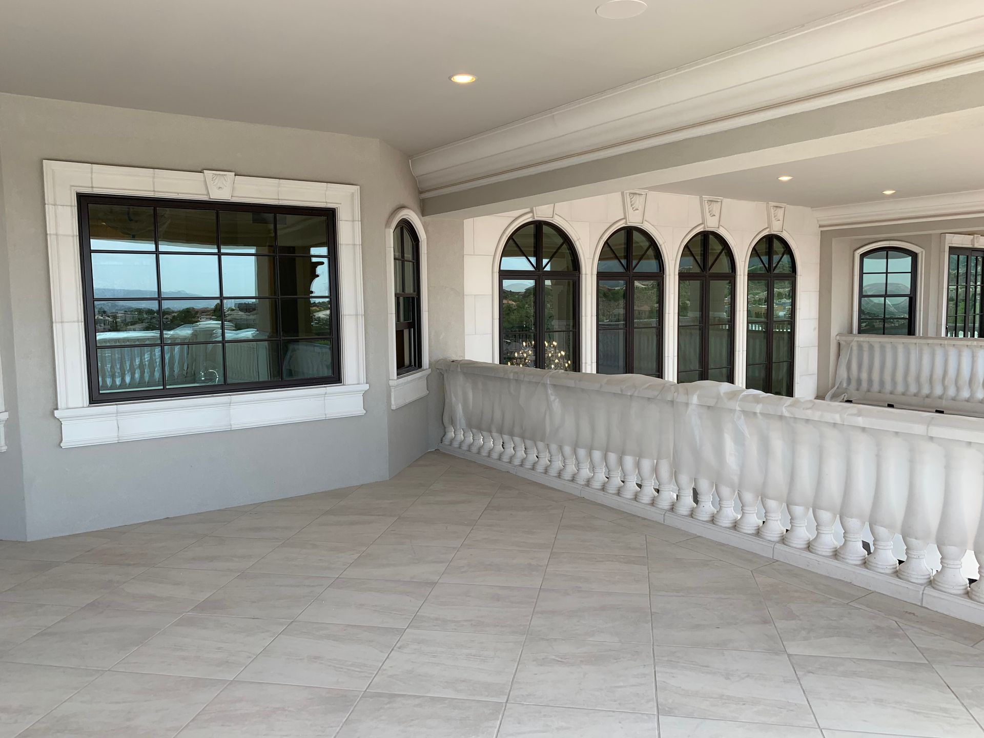 A large empty room with a balcony and lots of windows.