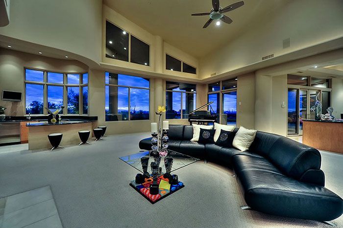 A living room with a black couch and a ceiling fan