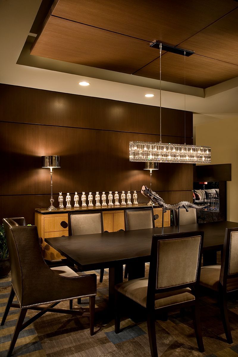 A dining room with a table and chairs and a chandelier hanging from the ceiling