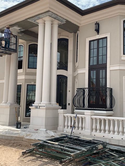 A large house with columns and a balcony under construction