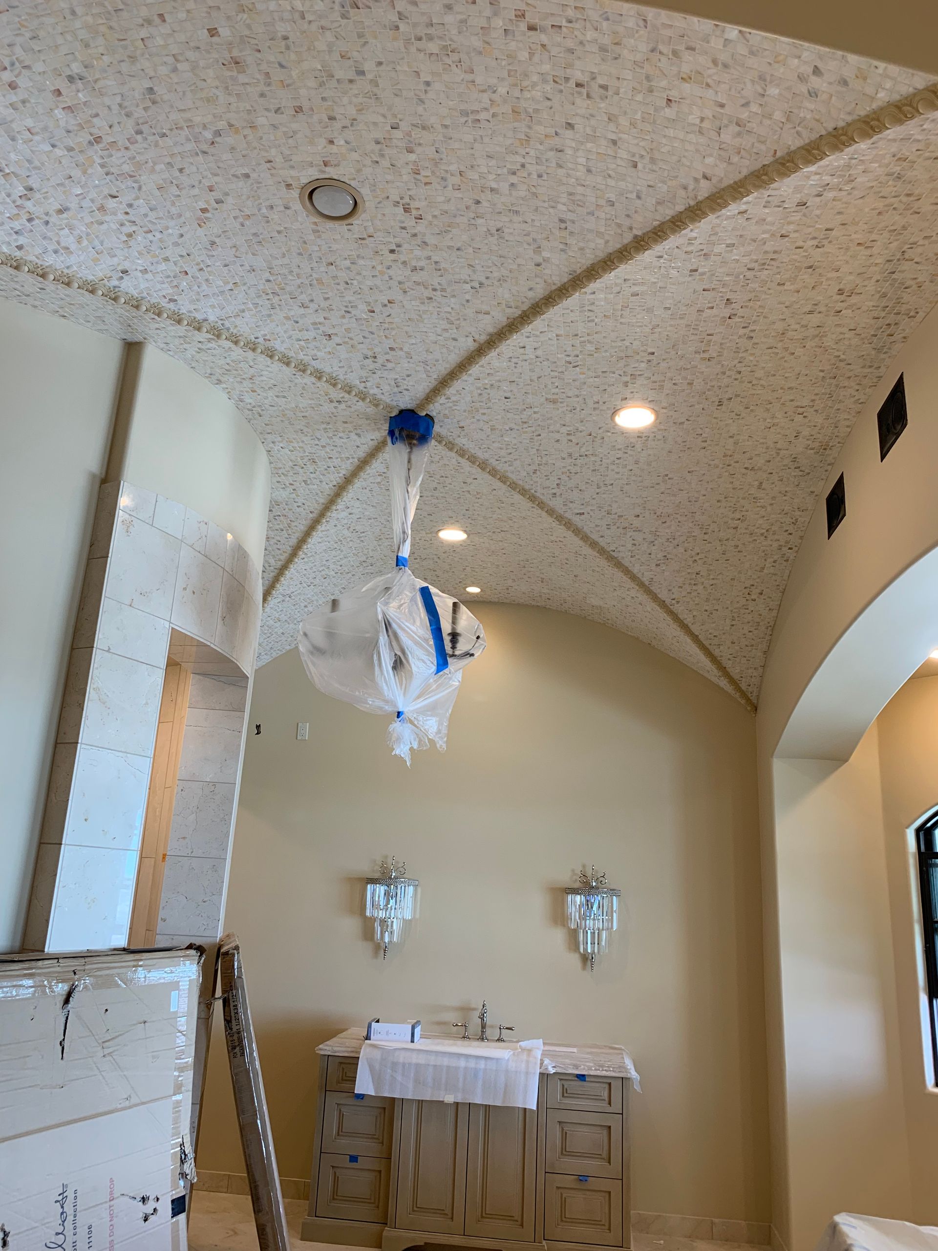 A bathroom with a vaulted ceiling and a chandelier hanging from it.