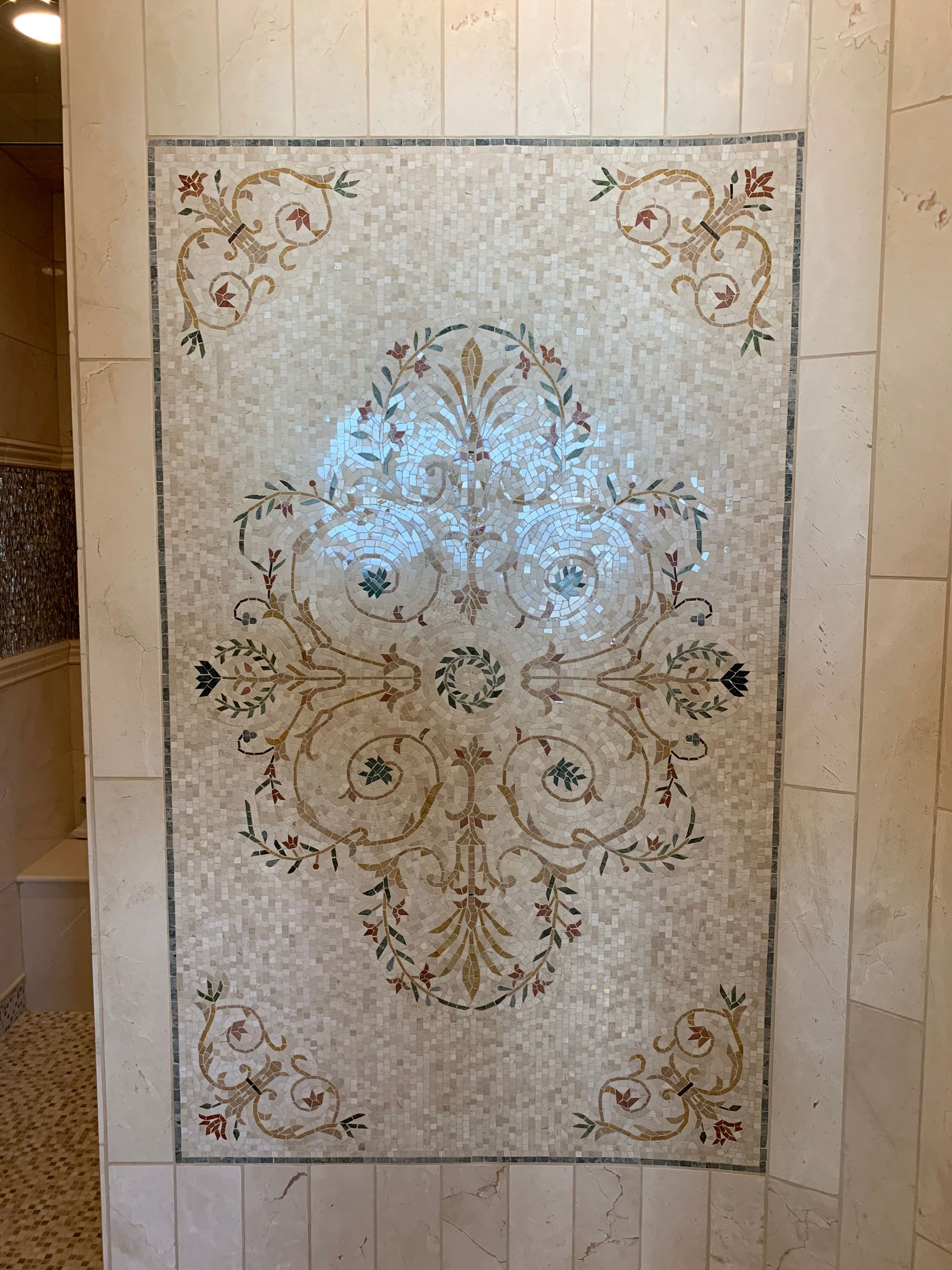 There is a mosaic on the wall in the bathroom.