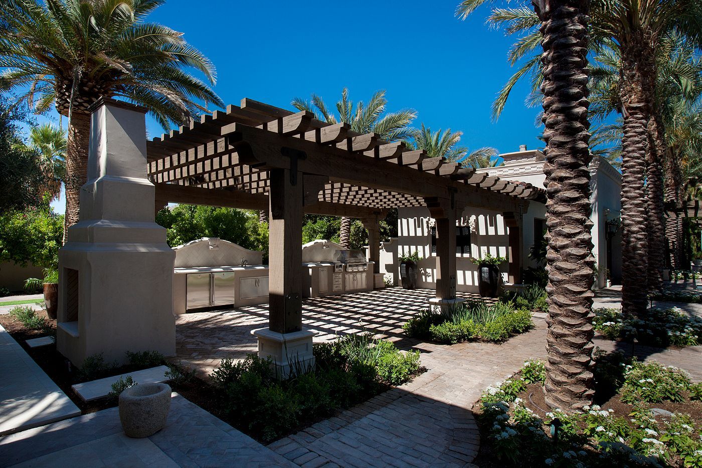 A patio area with a pergola and palm trees