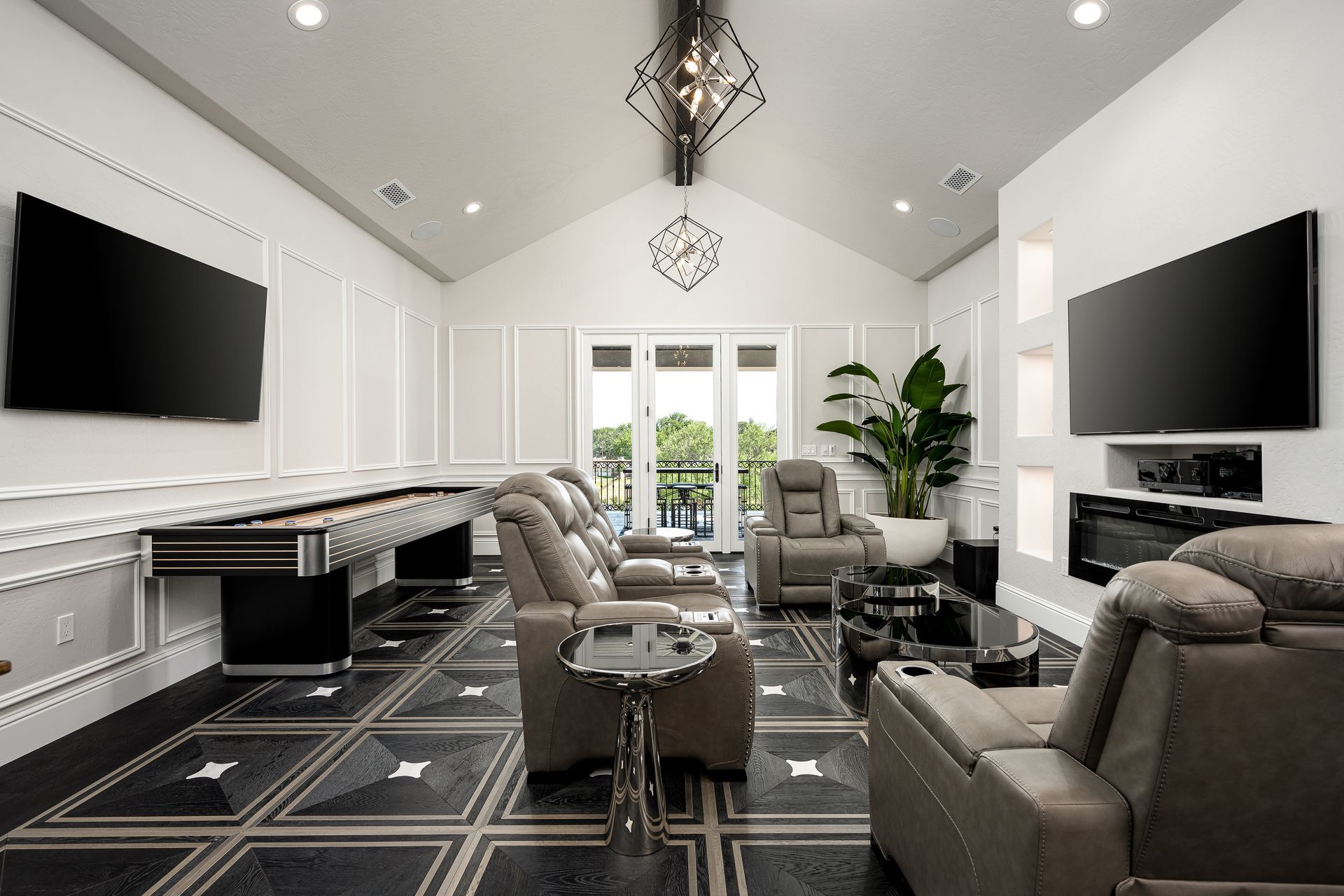 A living room with a pool table and two flat screen tvs