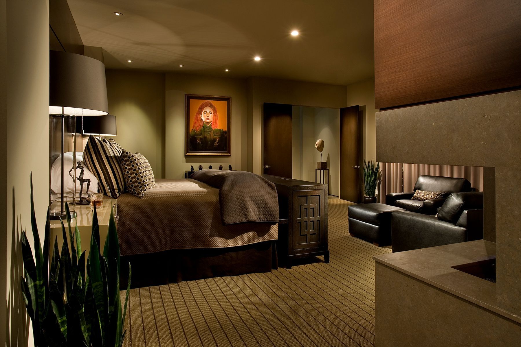 A bedroom with a large bed and a fireplace