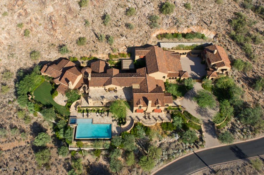 An aerial view of a large house with a pool