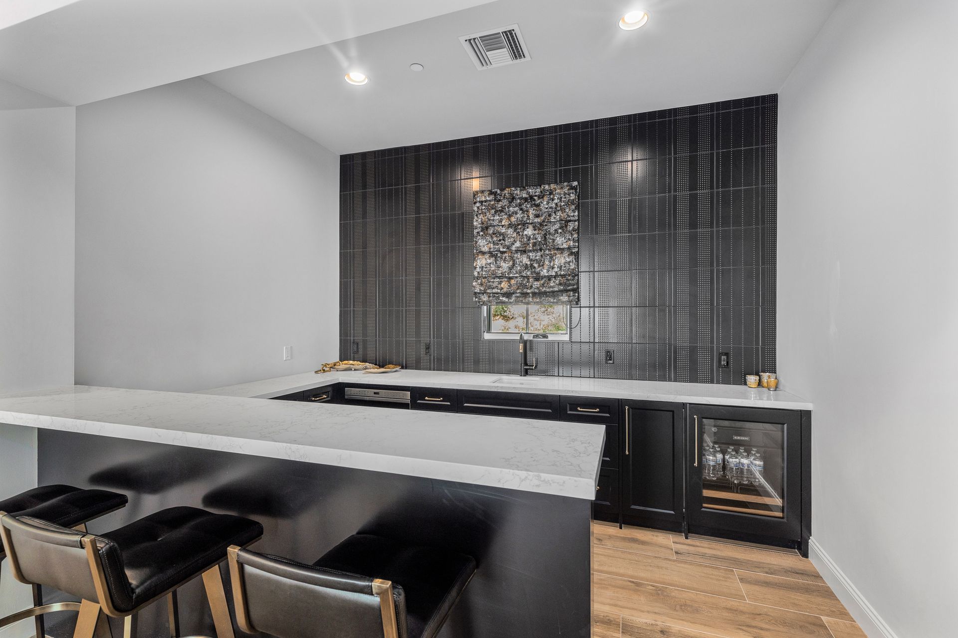 custom luxury bar with black cabinets and grey countertops