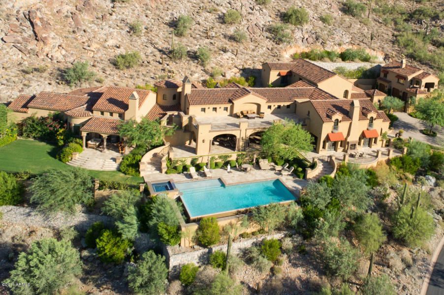An aerial view of a large house with a swimming pool