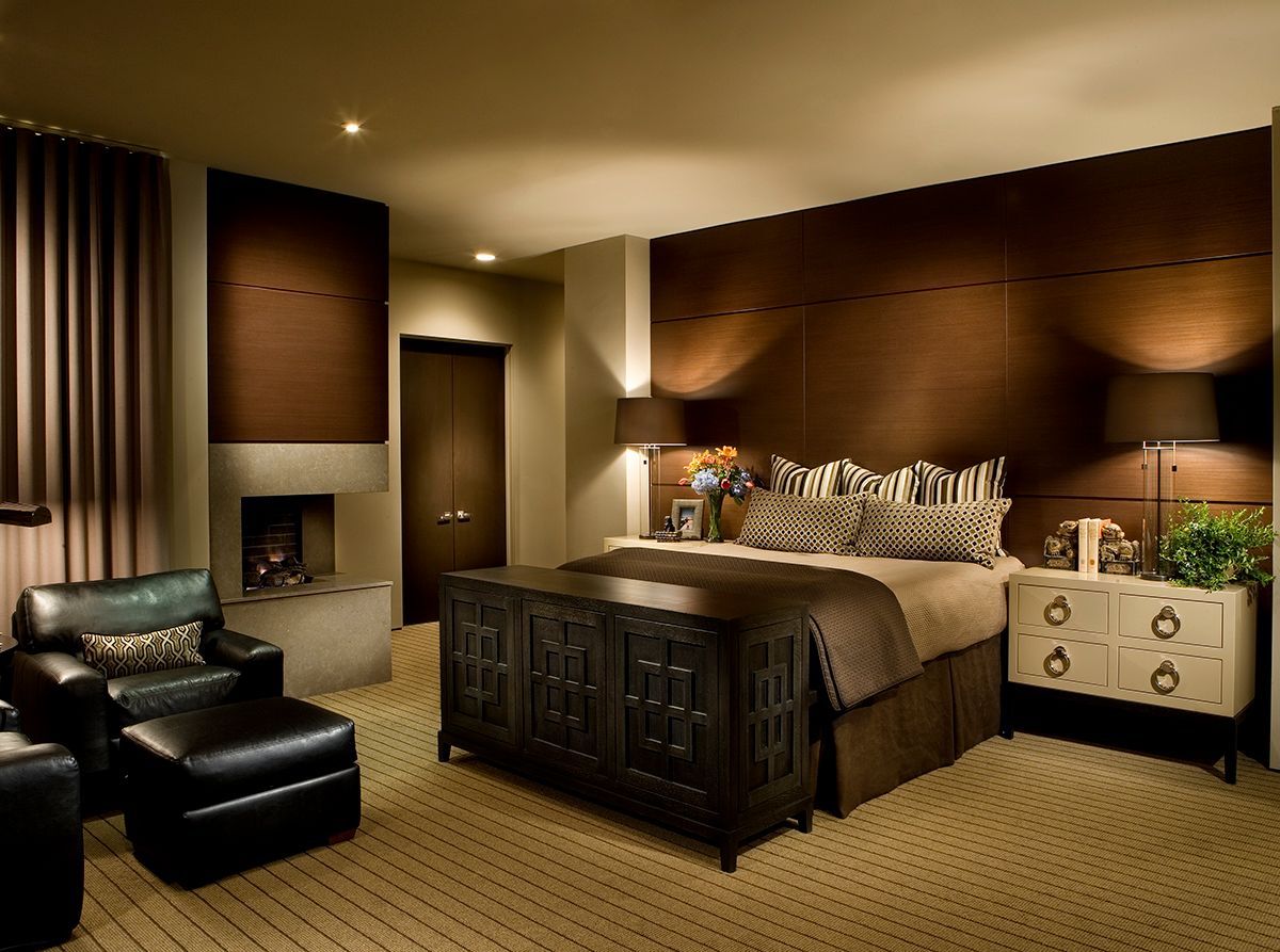 A bedroom with a large bed and a fireplace