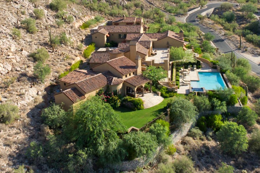 An aerial view of a large house with a swimming pool