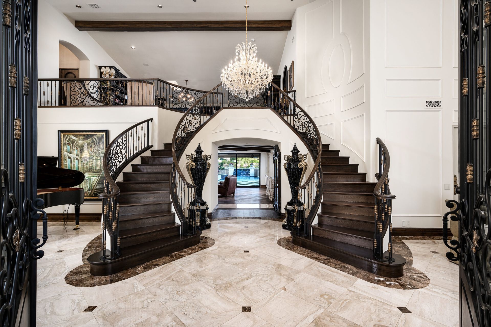 A large staircase in a house with a chandelier hanging from the ceiling.