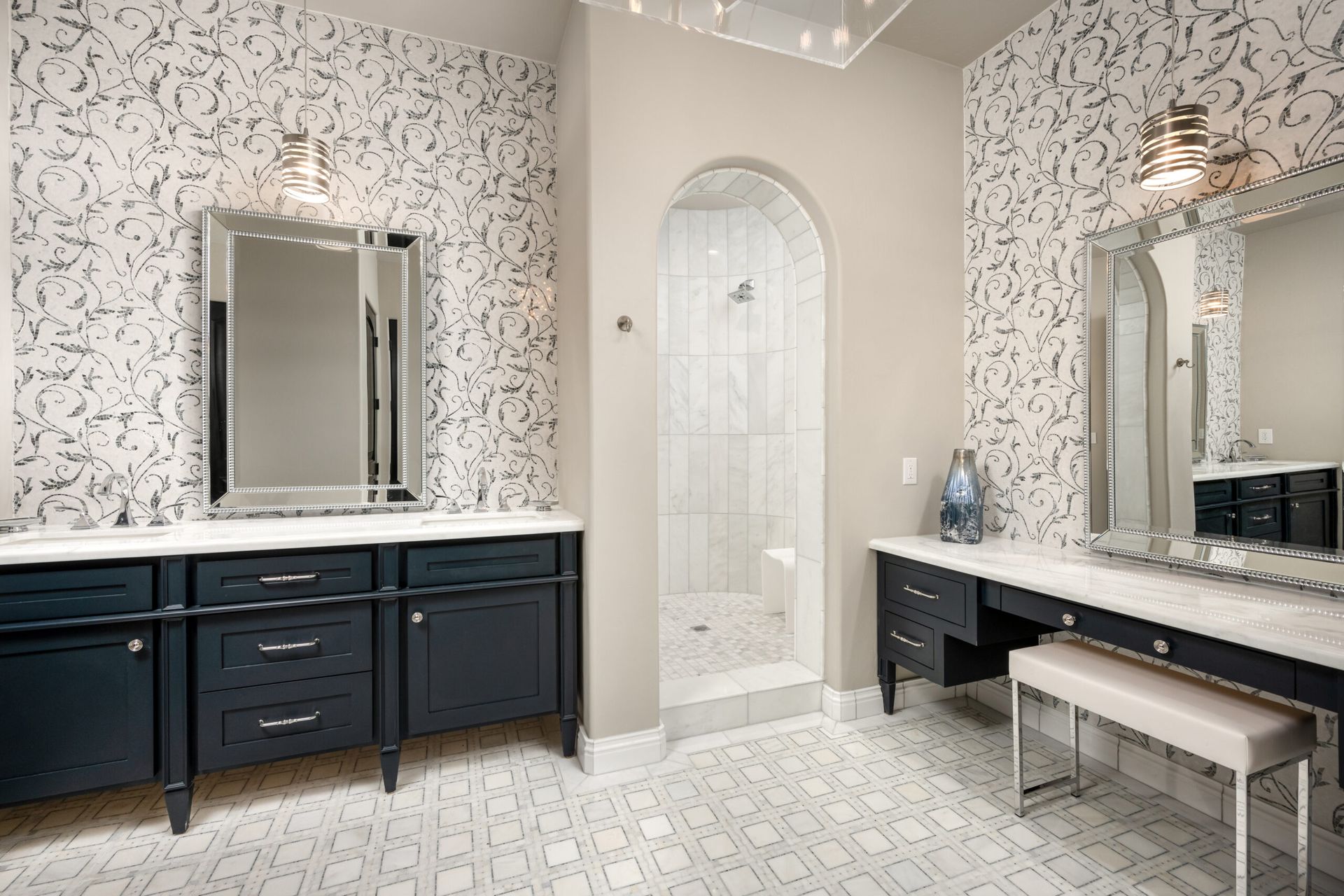 A bathroom with two sinks , two mirrors and a bench.