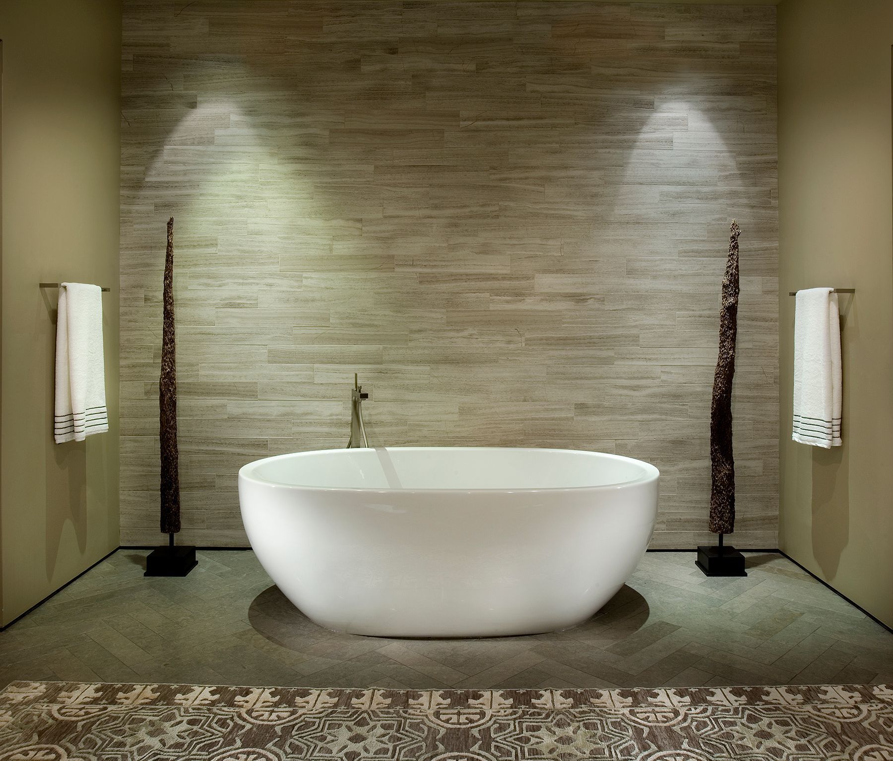 A bathtub in a bathroom with a brick wall