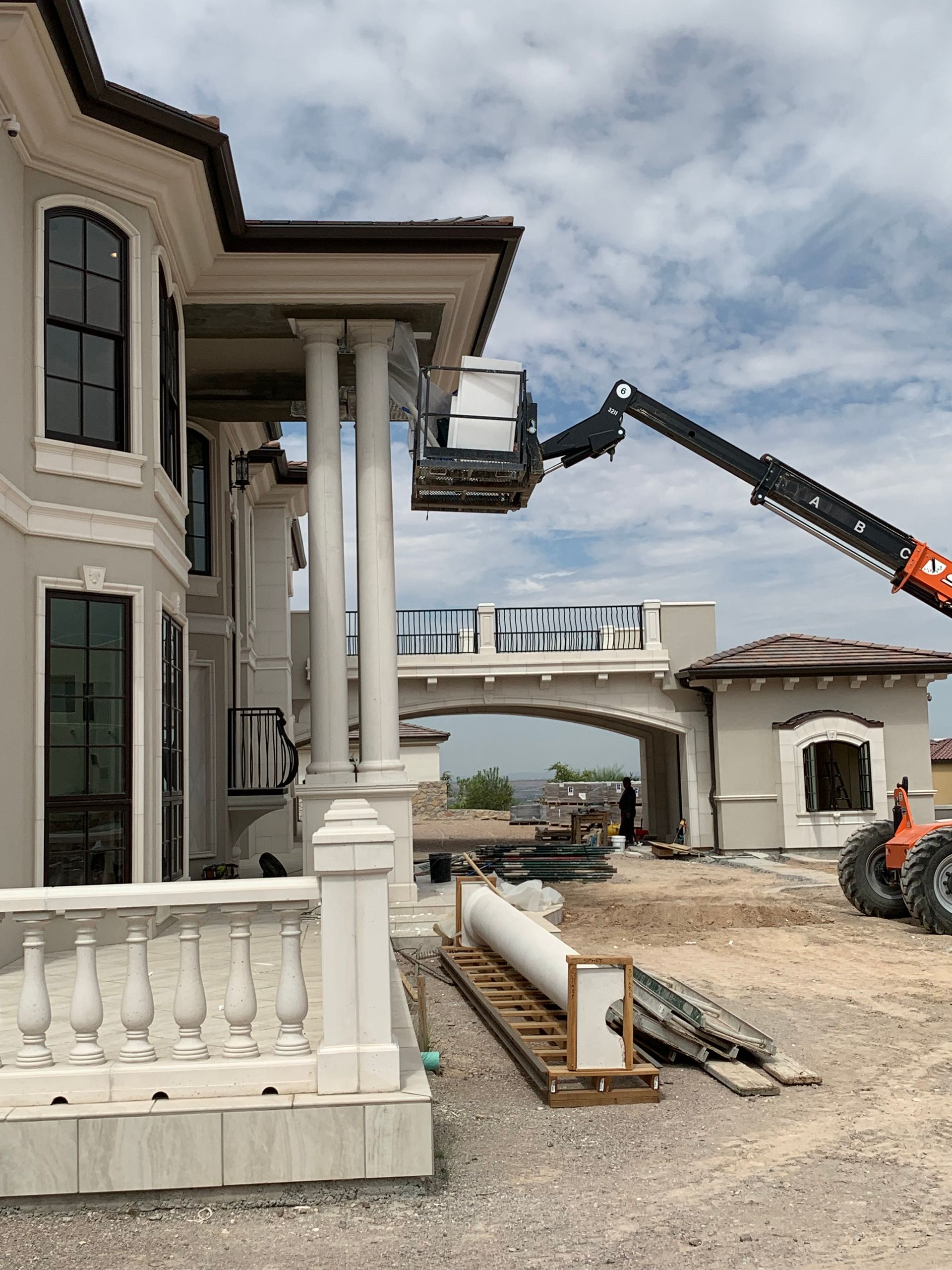 A large house is being built with a crane on the side