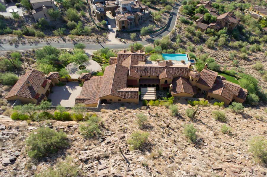 An aerial view of a large house in the middle of a desert.