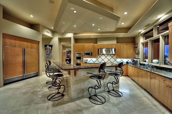 A kitchen with a large island and stools