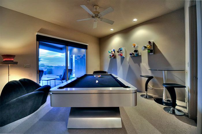 A pool table in a room with a ceiling fan