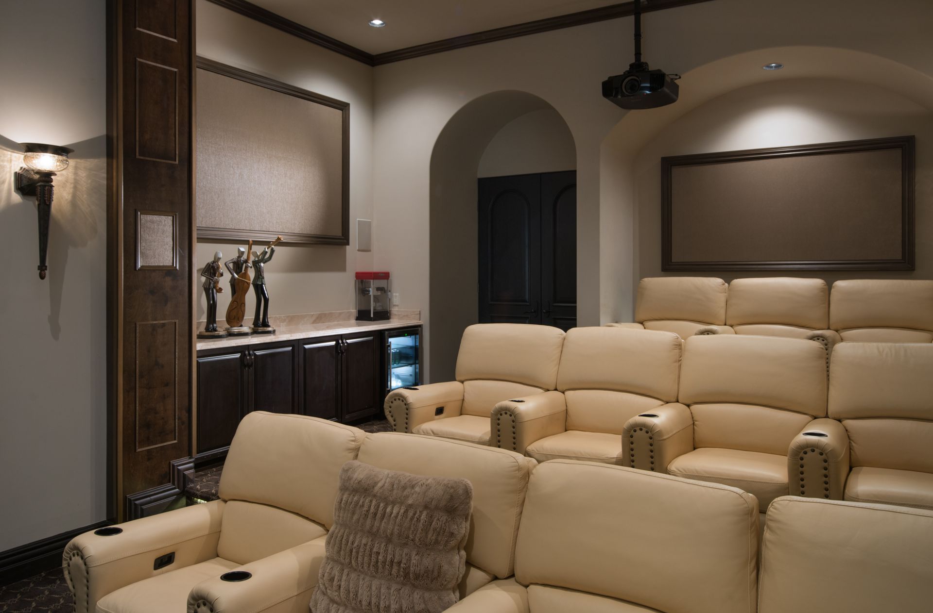 A home theater with a projector and a couch and chairs