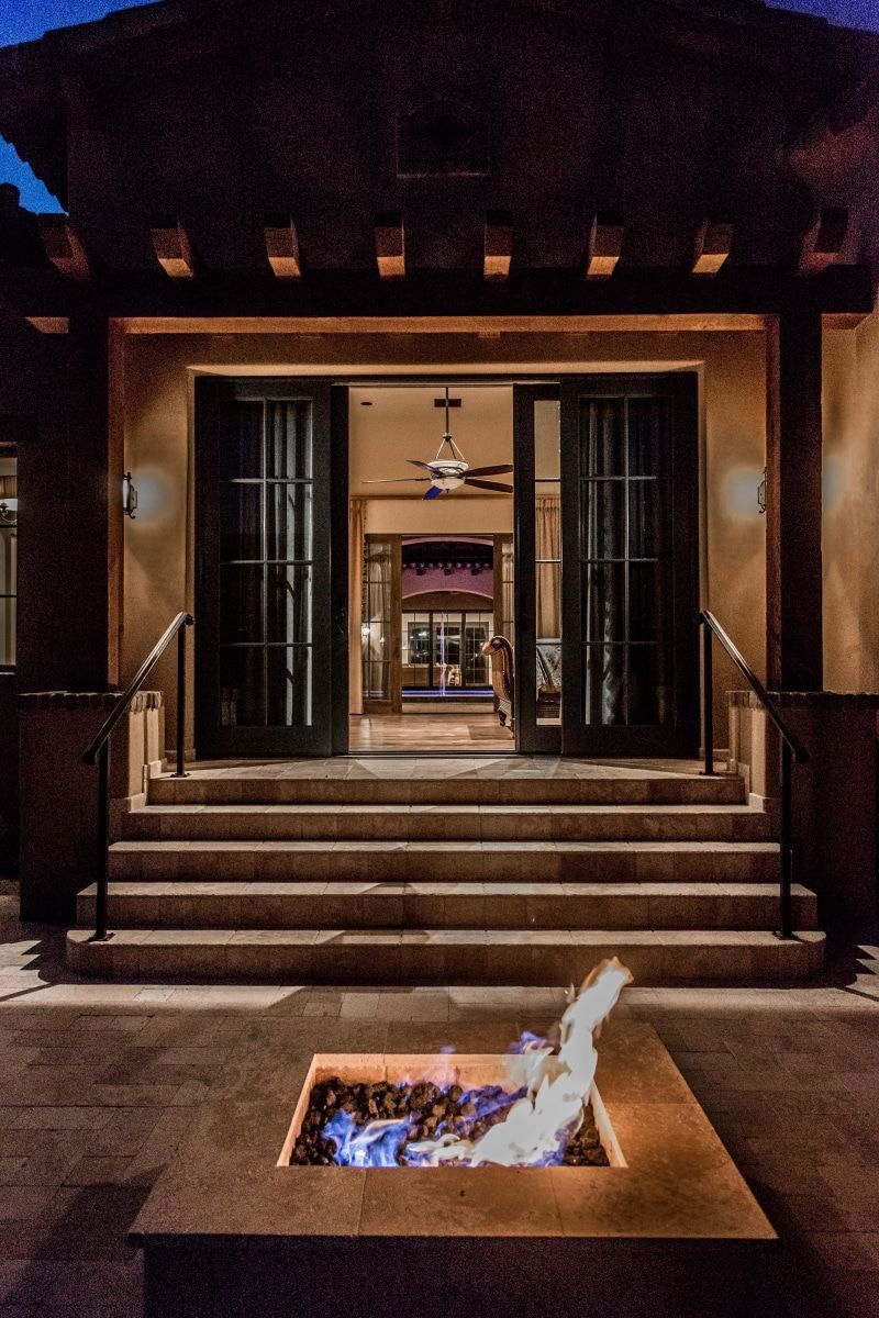 A fire pit in front of a house at night