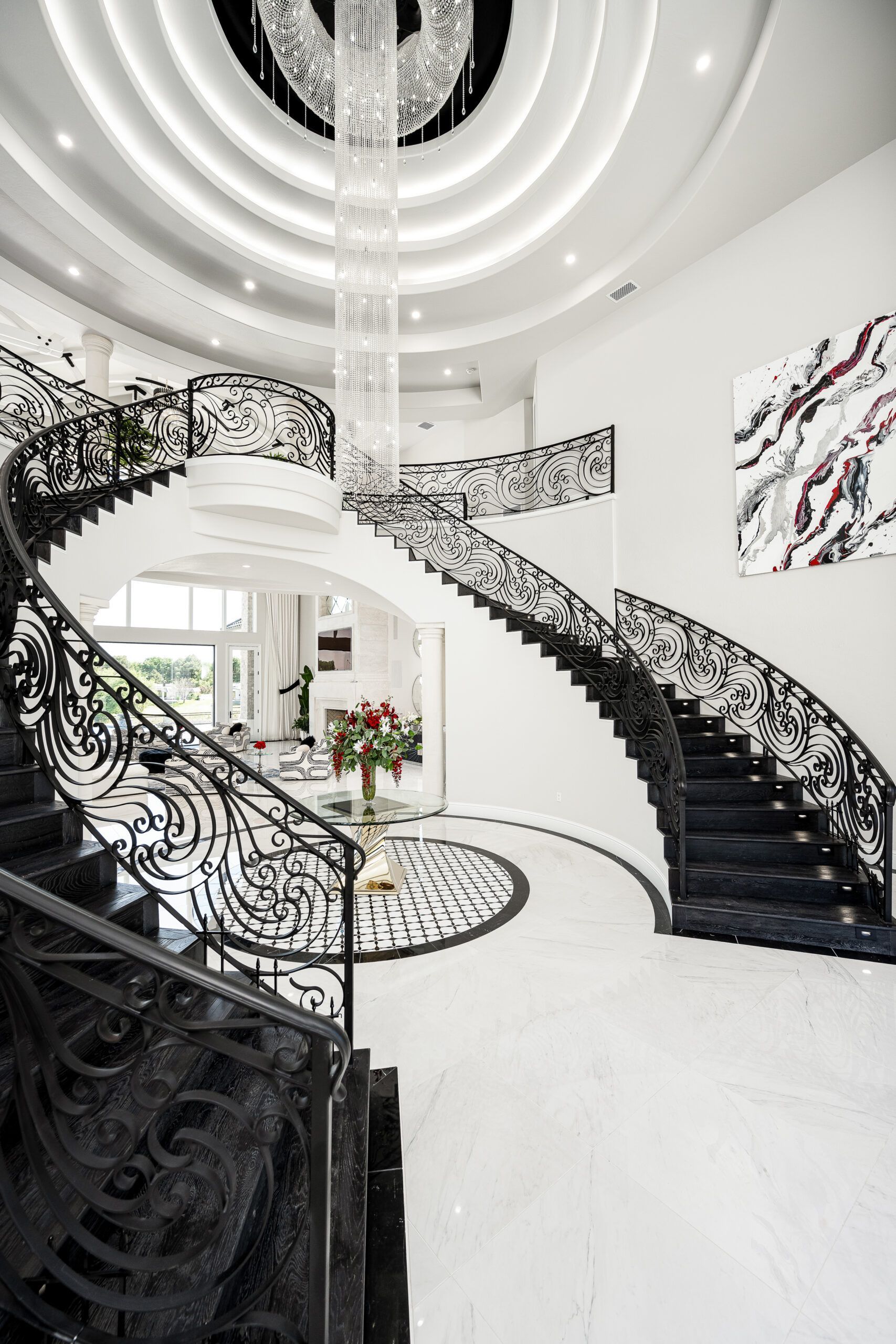 A black and white staircase with a chandelier hanging from the ceiling