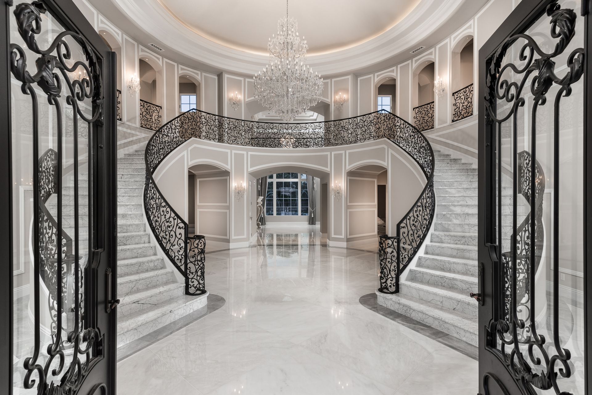 mansion foyer with double staircase and chandelier