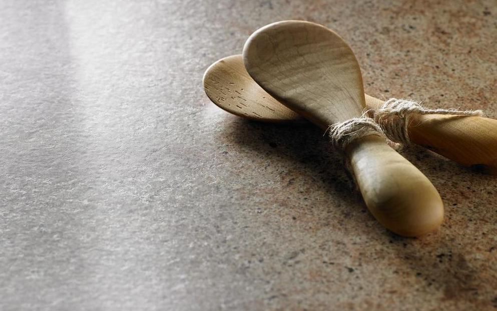 Two wooden spoons are sitting on a counter.