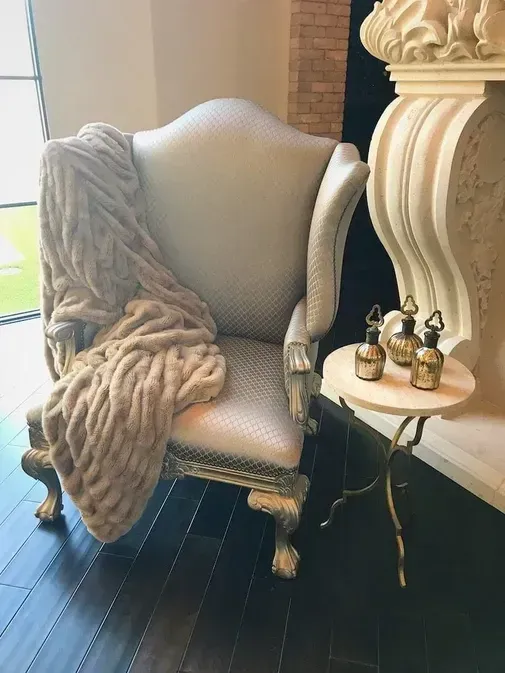 Carved Wood Chair, Faux Fur Throw, and Marble Side Table
