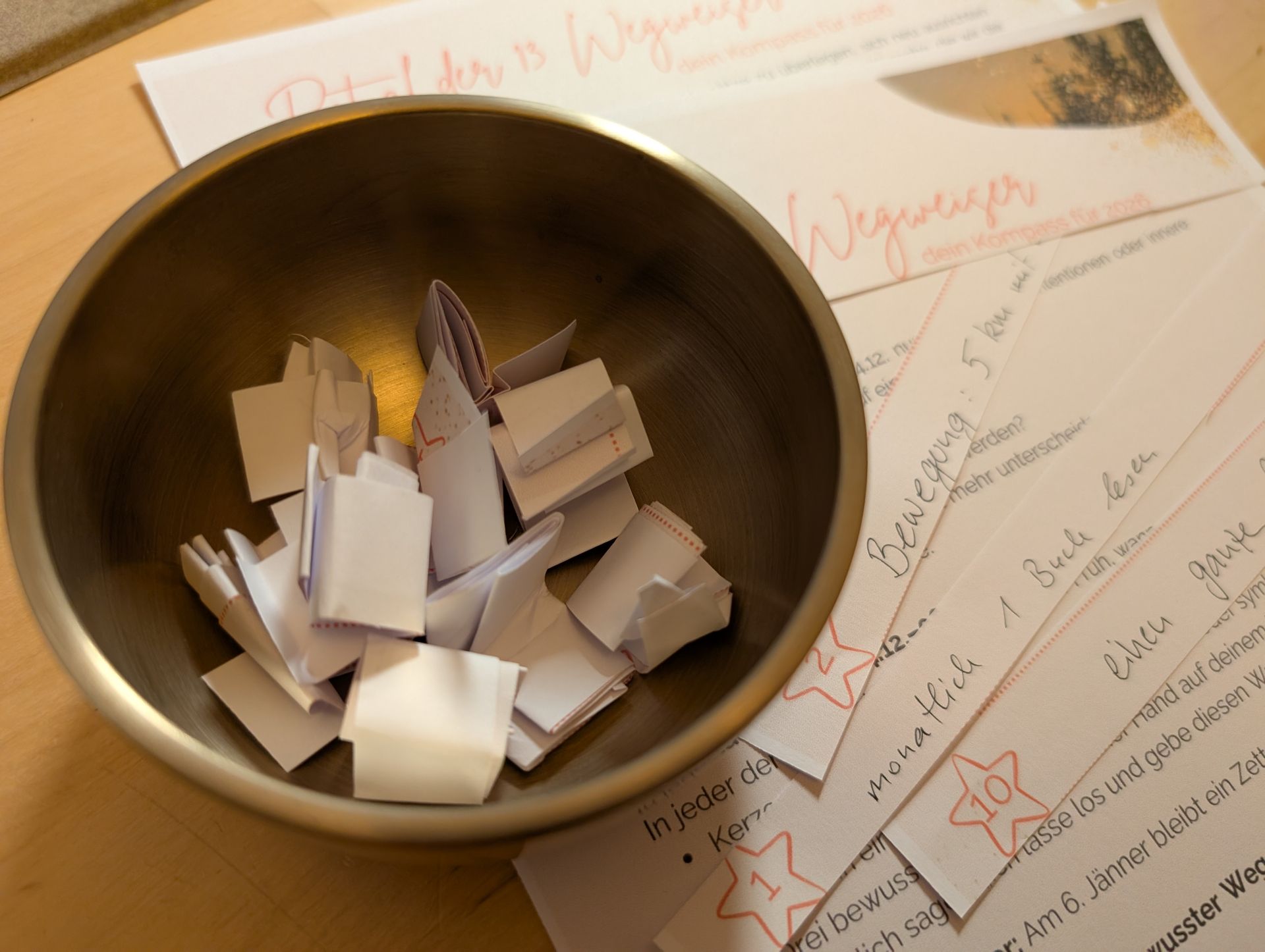 Klangschale mit gefalteten Zetteln auf denen Neujahrsvorsätze geschreiben sind.