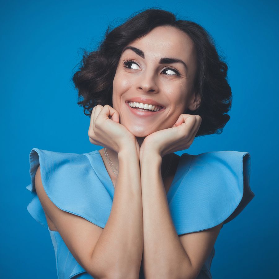 Woman looking at her new smile in the mirror