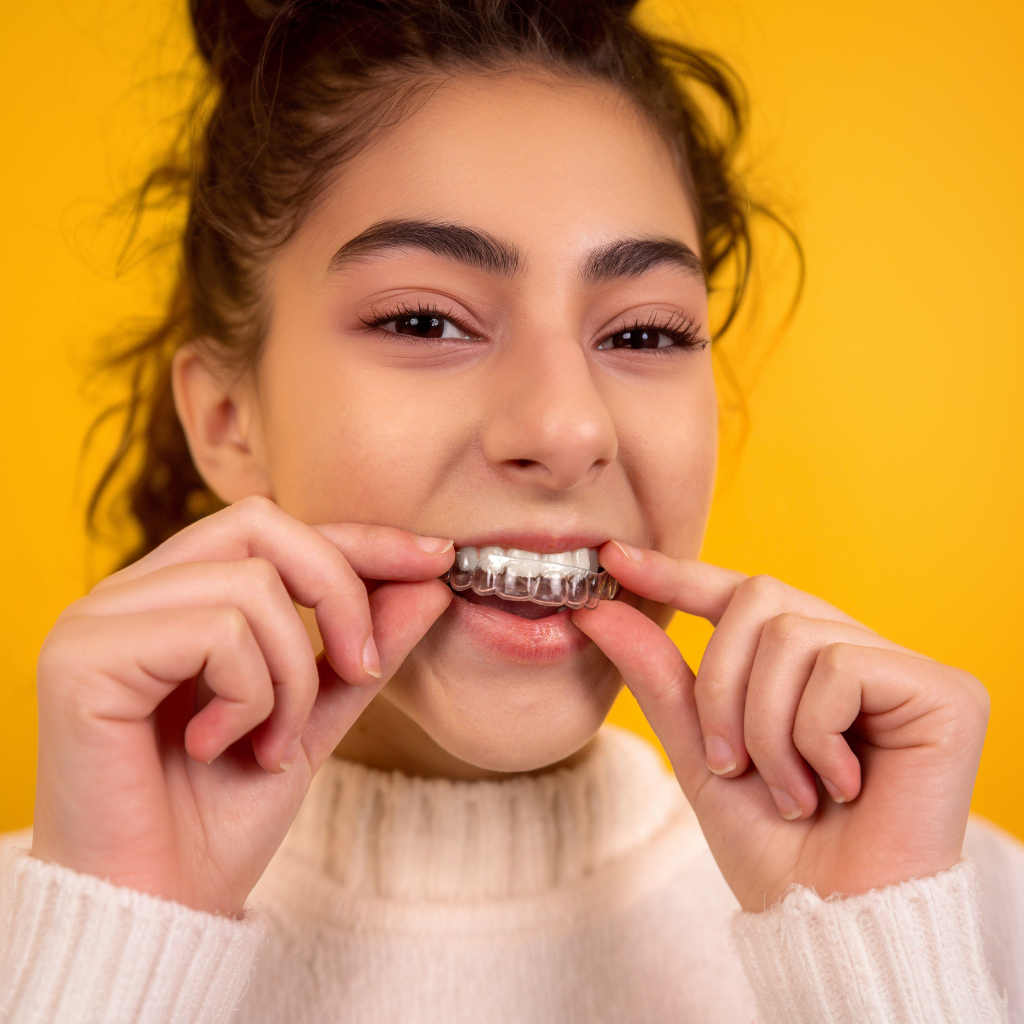Woman looking at her new smile in the mirror