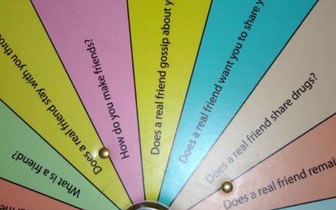 A wheel with a bunch of questions on it including does a real friend share drugs