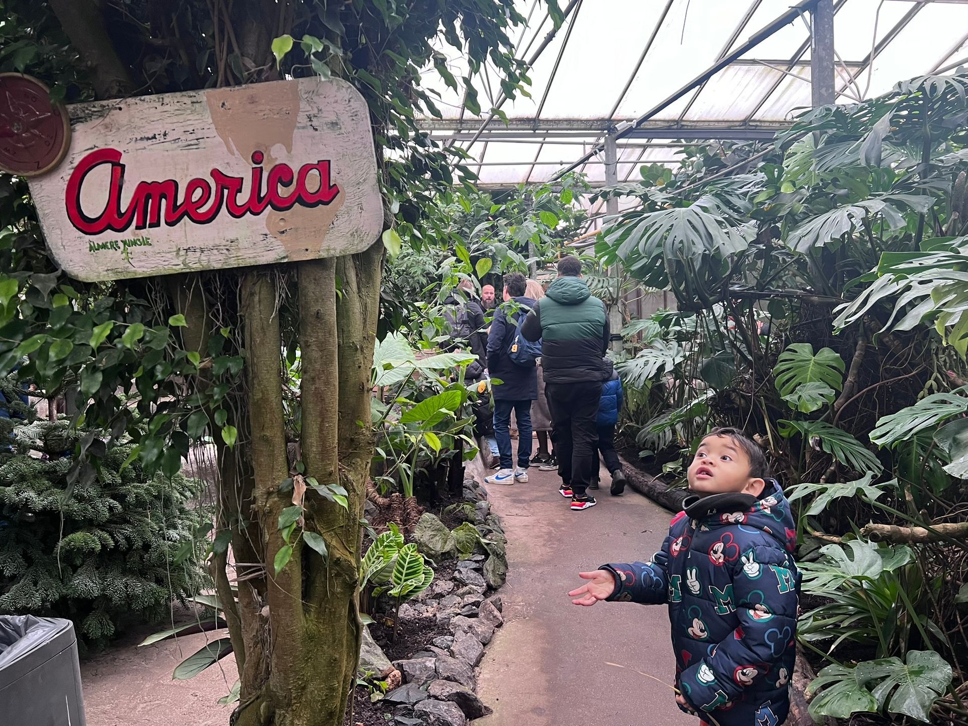 Een jongetje staat voor een bord waarop ``Amerika'' staat.