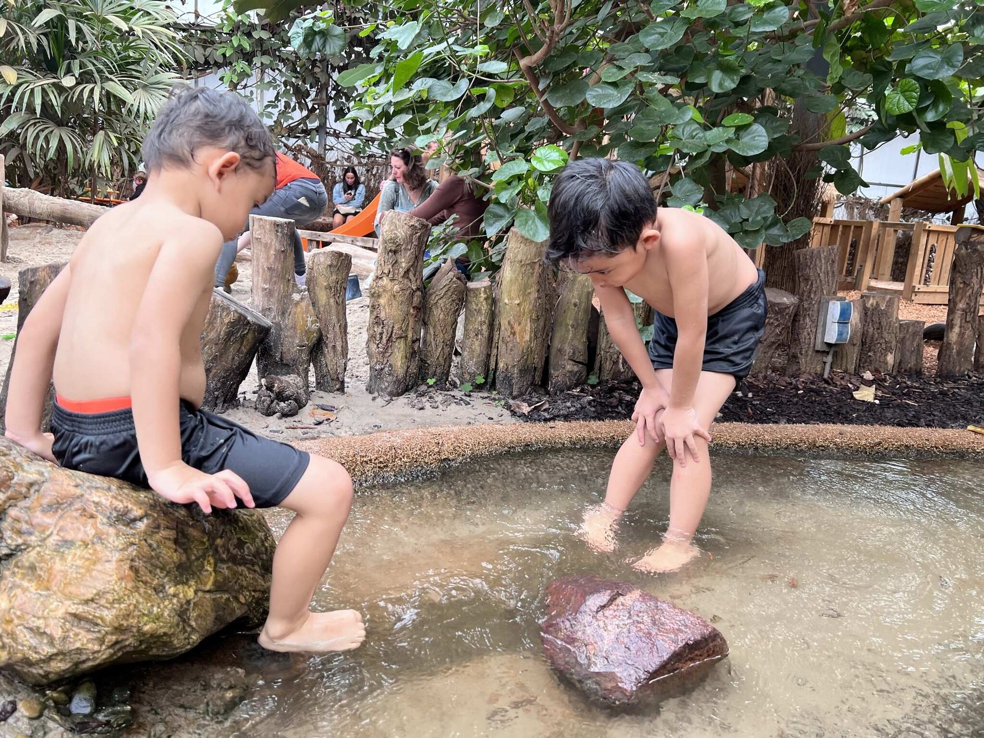 Twee jonge jongens spelen in een waterpoel.