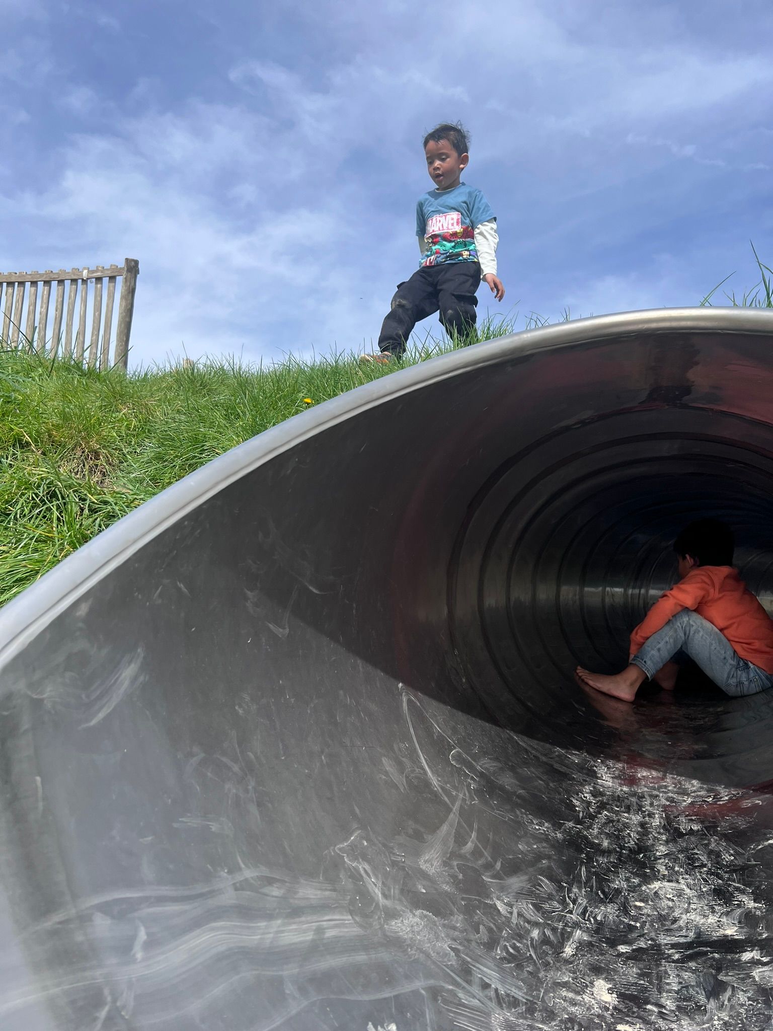 Een jonge jongen staat bovenop een glijbaan.