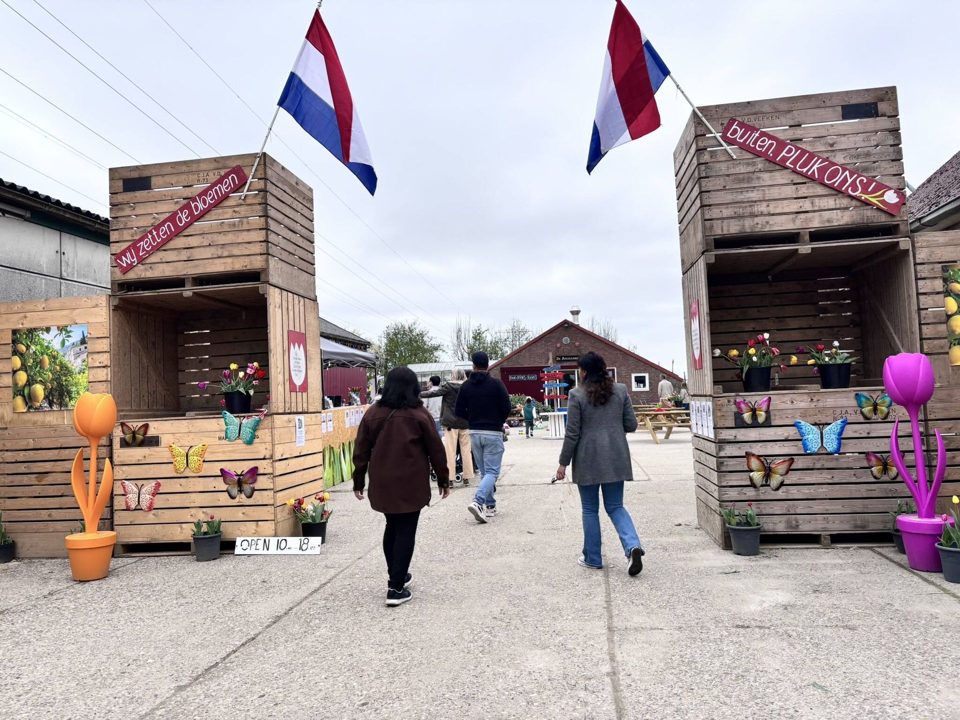 Een groep mensen loopt over het trottoir voor een houten gebouw.