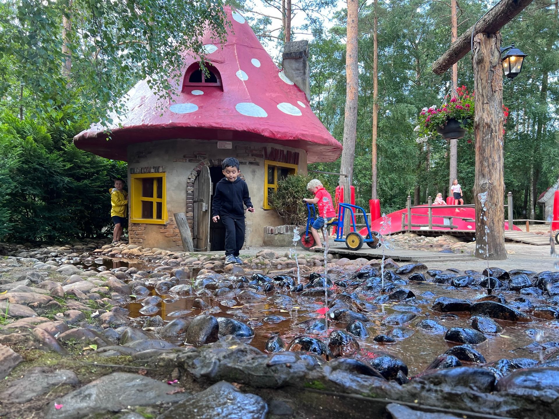 Een kind staat voor een paddenstoelenhuisje in het Grote Kabouterbos.