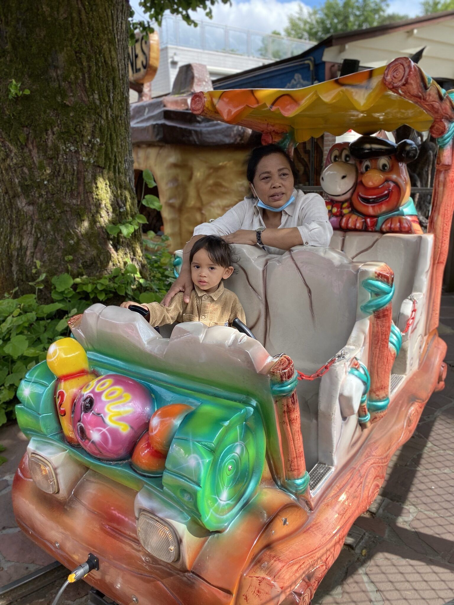 Een vrouw en een kind zitten in een kermisattractie.