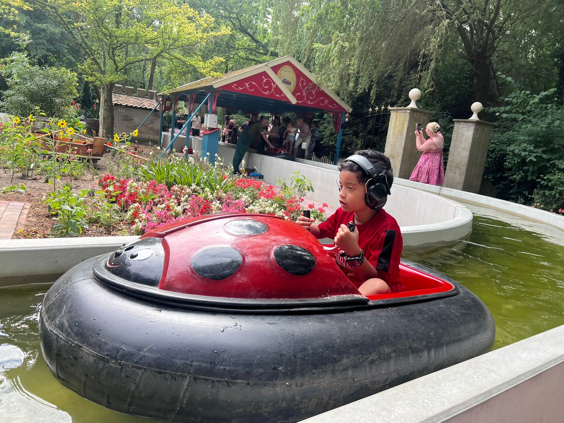 Een jonge jongen vaart in een botsbootje in een vijver.