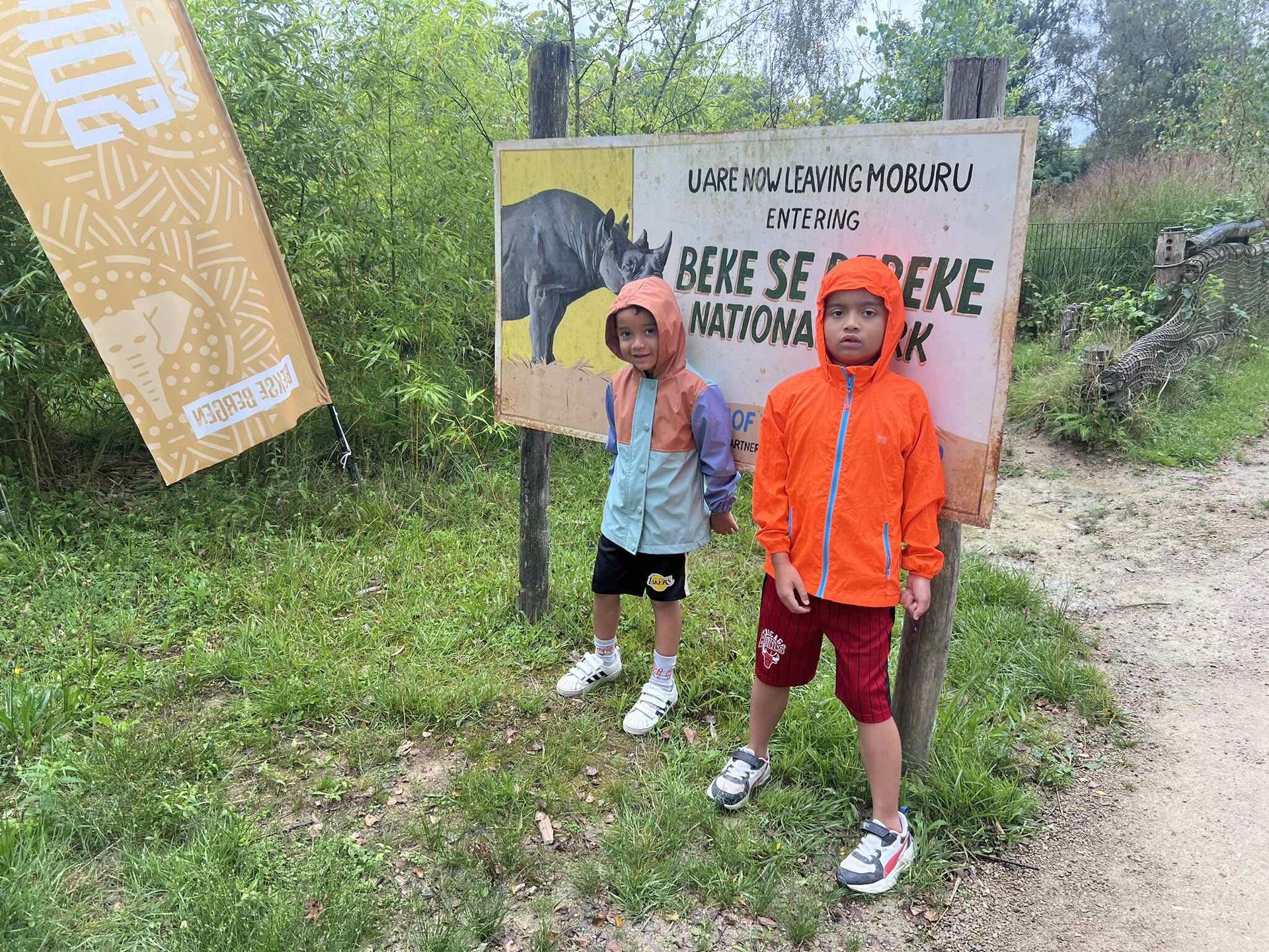 Twee jonge jongens staan voor een bord.
