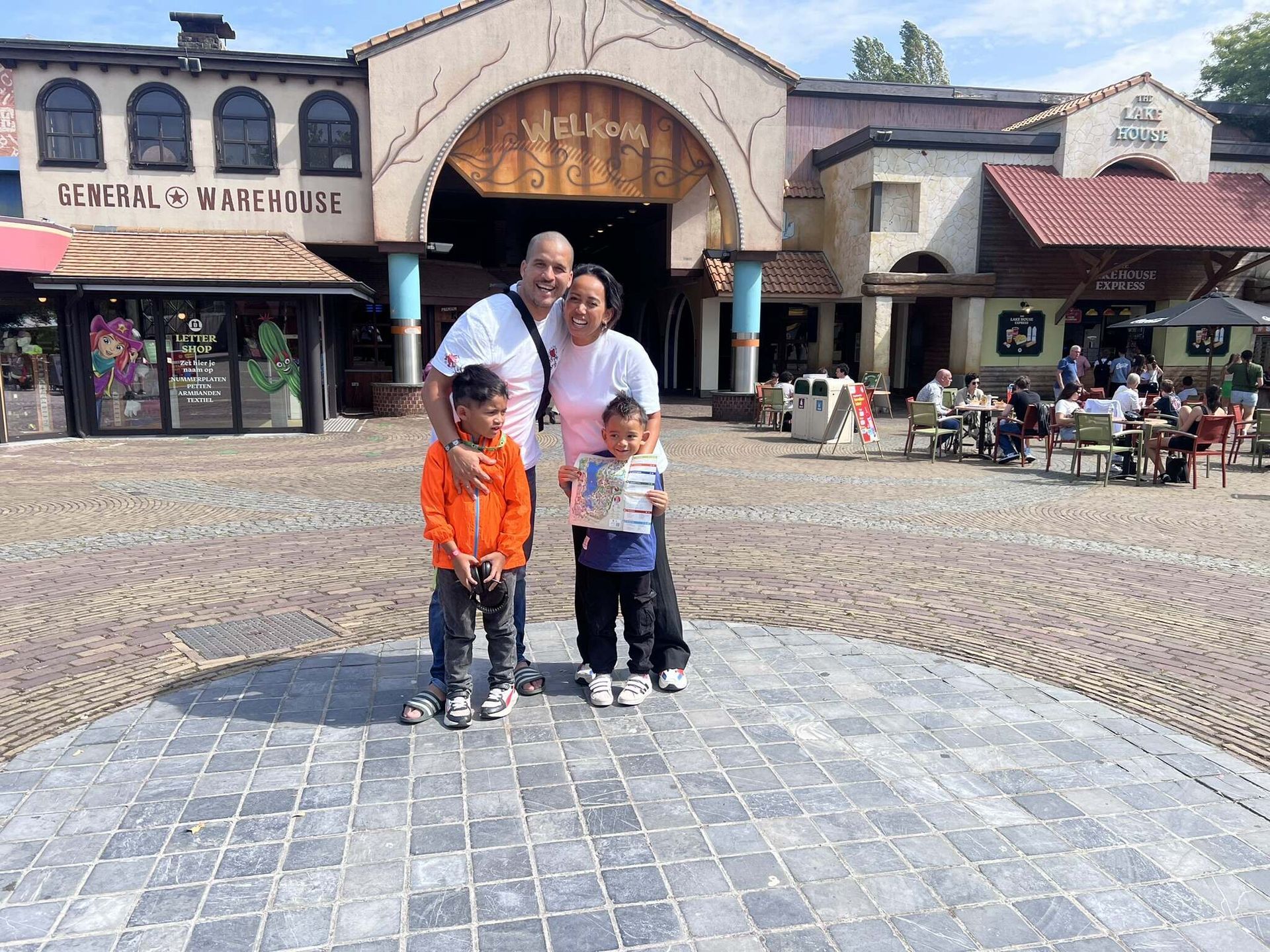 Een gezin poseert voor een foto voor de entree bij Bobbejaanland. 