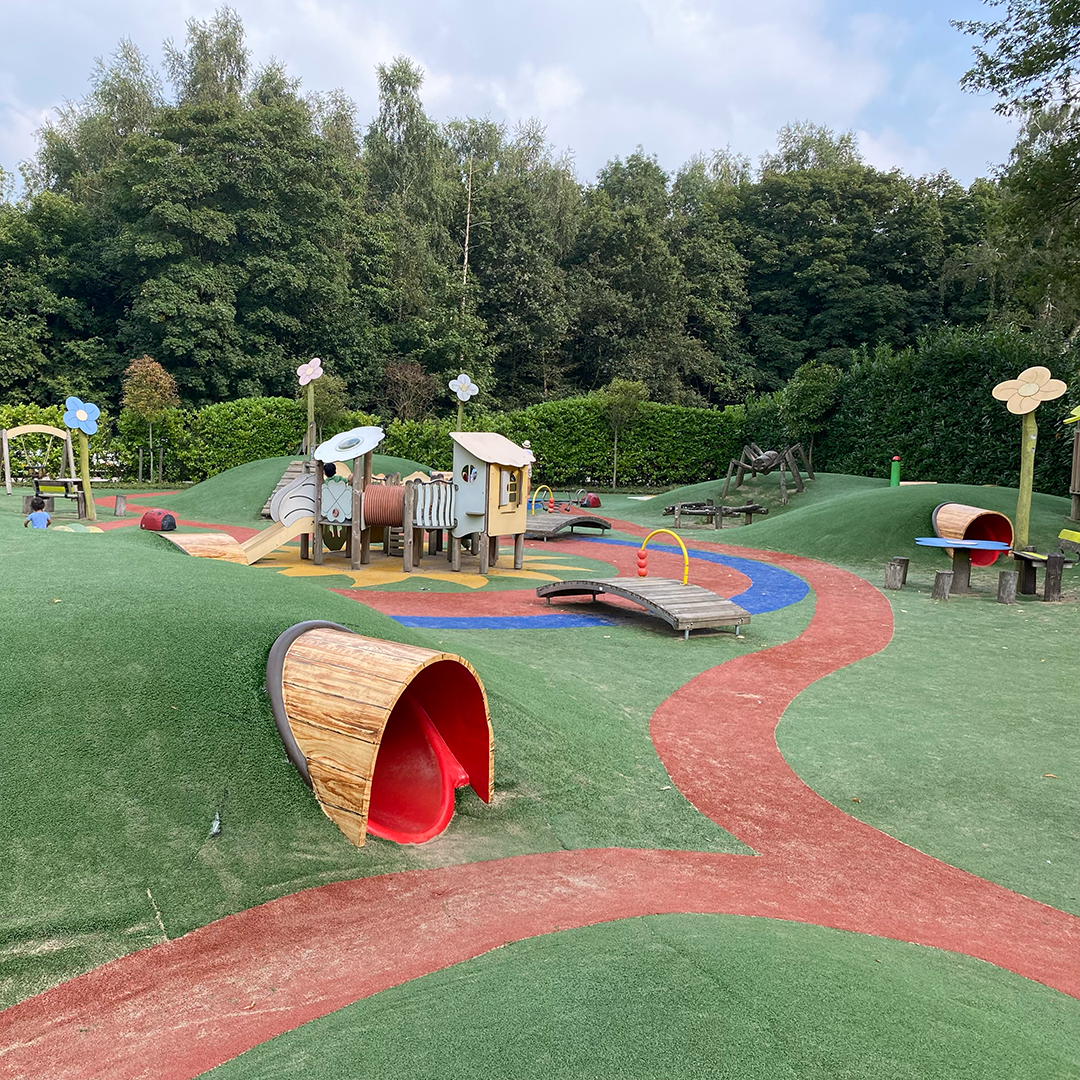 Een speeltuin met een treintje en een tunnel in het midden in Oud Valkeveen