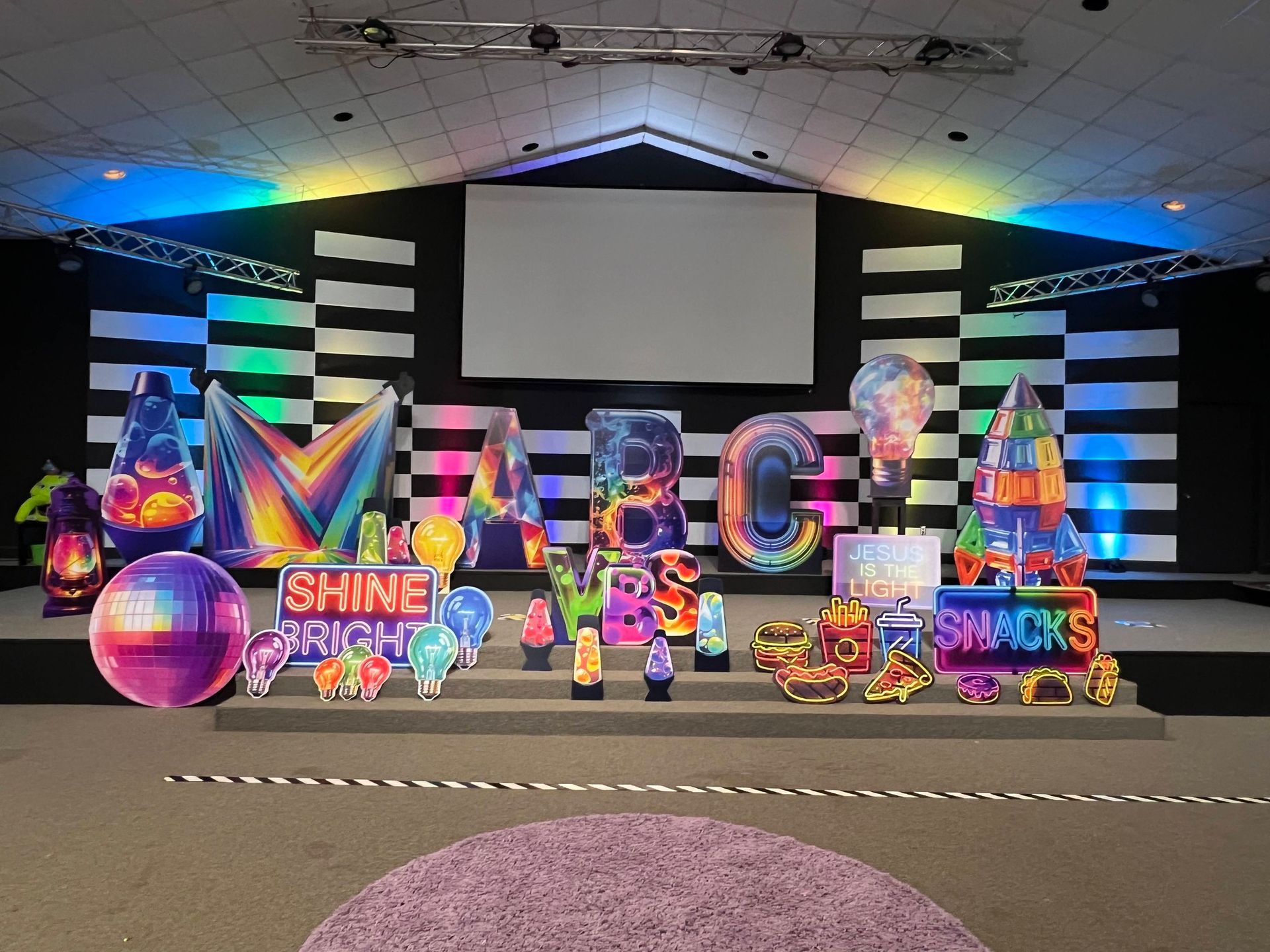 Stage setup with colorful light displays spelling 