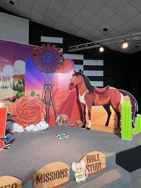 Stage set: Western theme with horse cutout, windmill, cactus, and