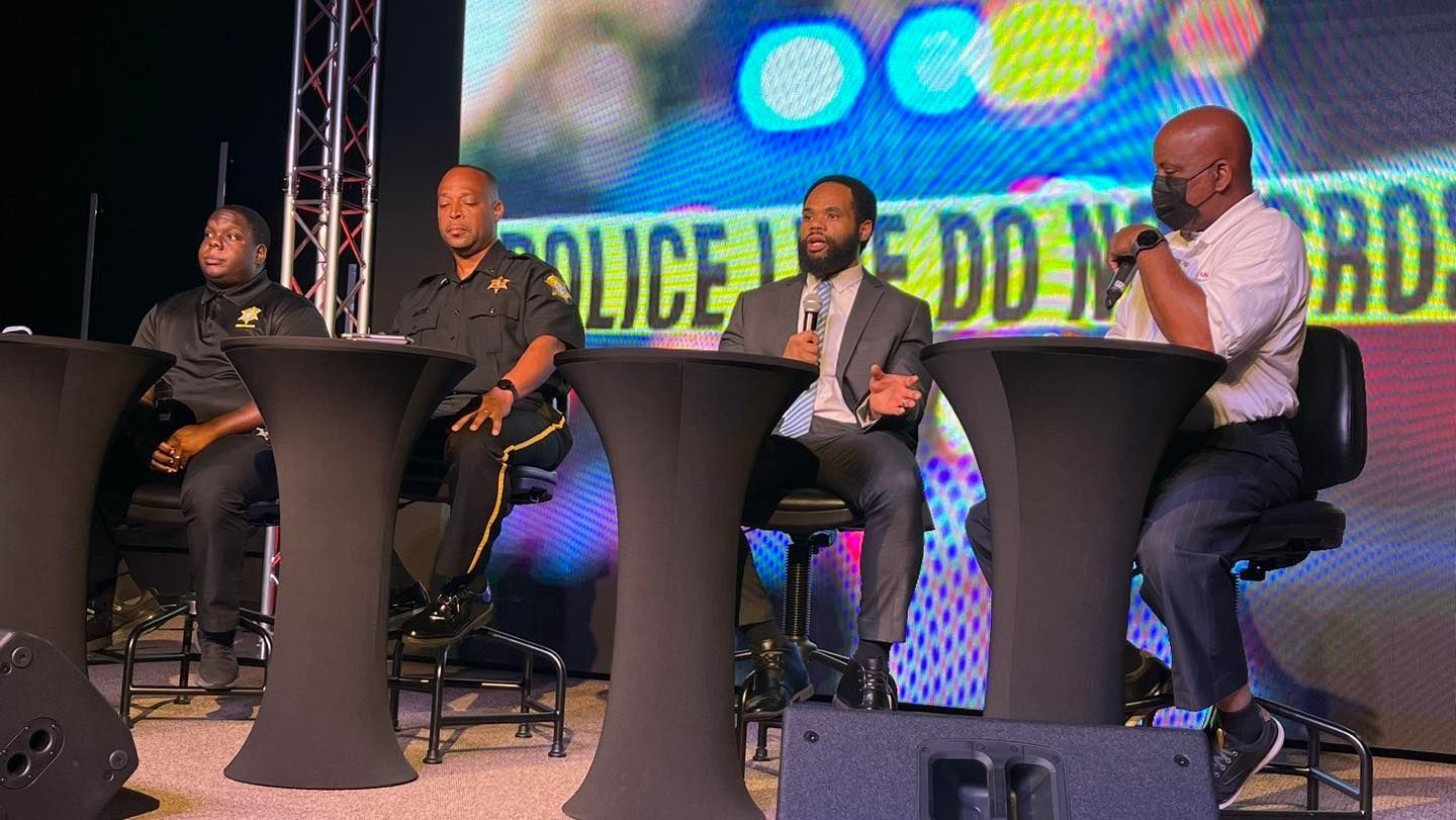 A group of men are sitting at tables talking to each other.