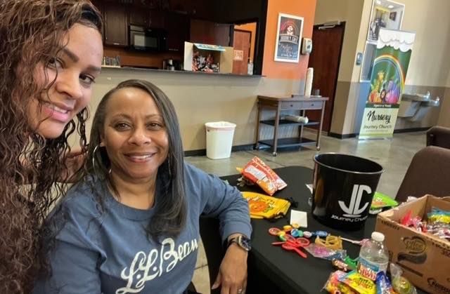 Two women are posing for a picture while sitting at a table.