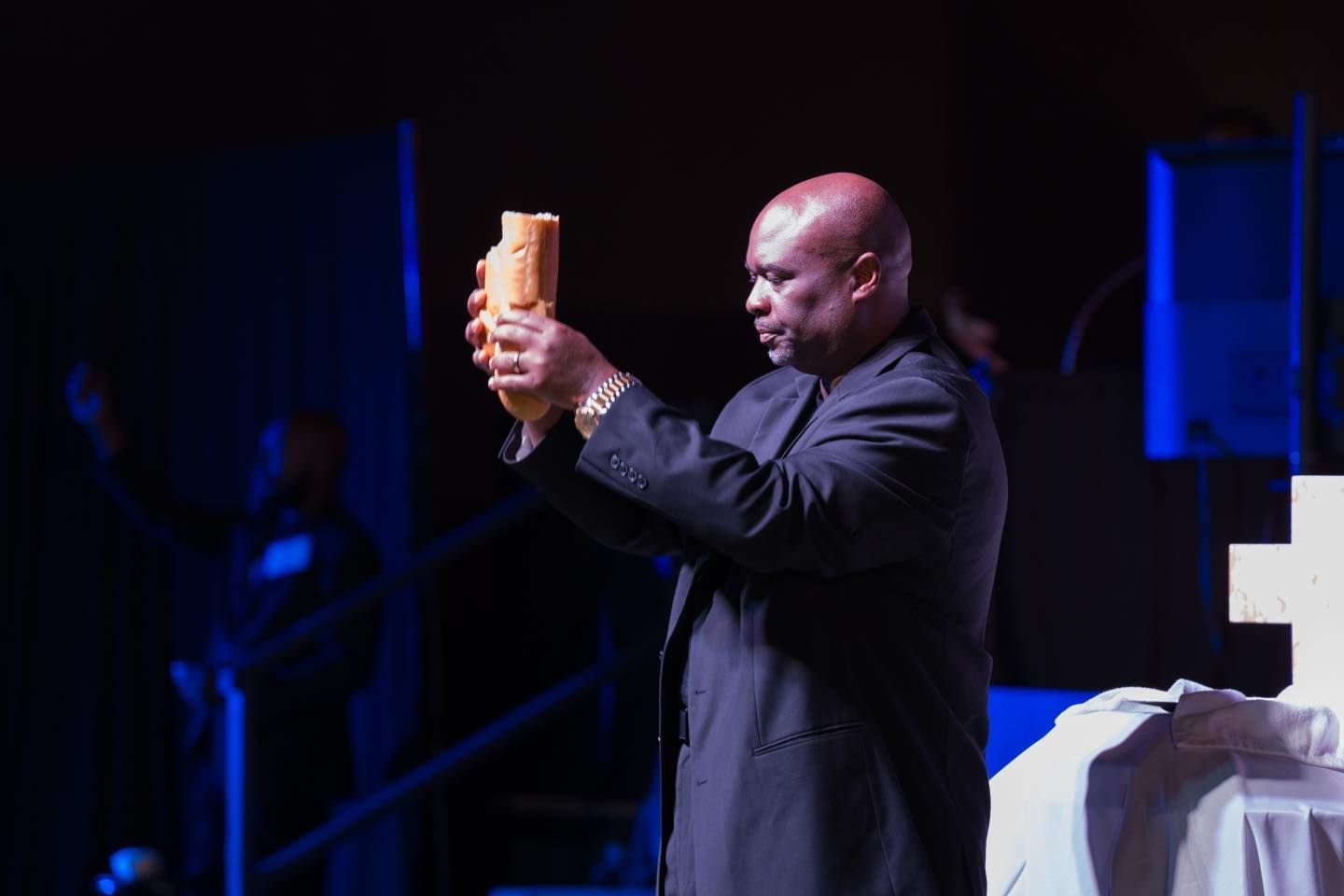 A man in a suit is holding a piece of bread in his hands.