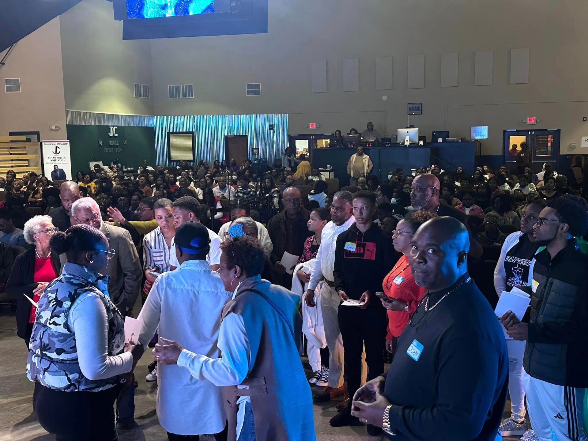 A large group of people are standing in a large room.