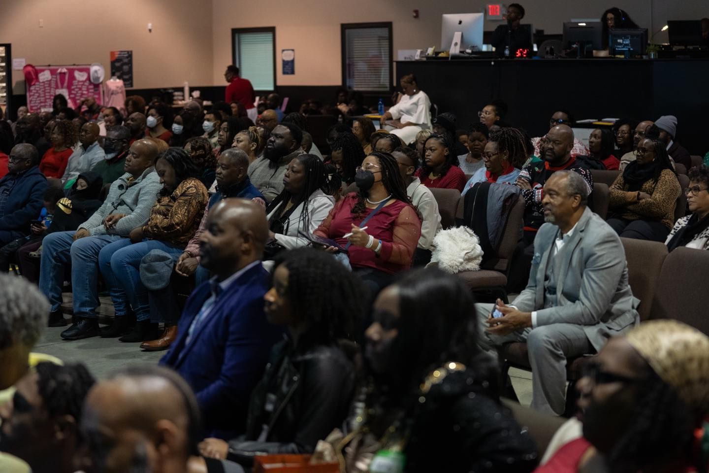 A large group of people are sitting in chairs in a room.